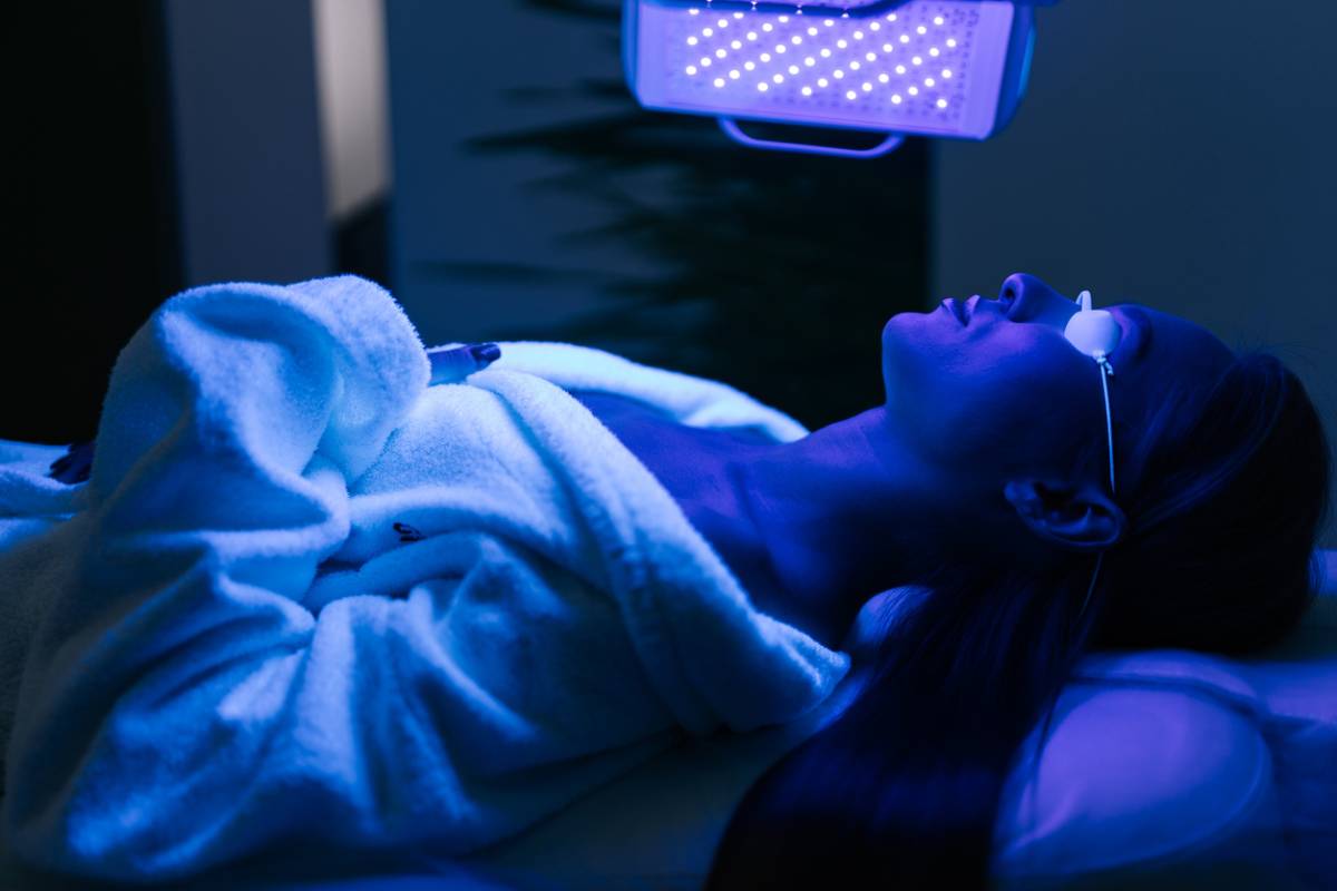 woman enjoying the benefits of led light therapy with blue light on bed